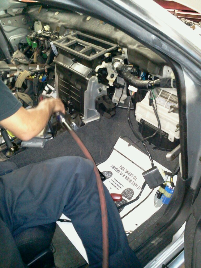 A mechanic performing repairs on the car's front end, using specialized tools and equipment at Warminster, PA
